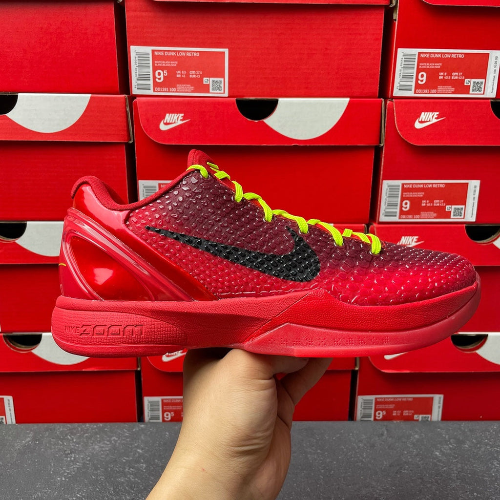 Red low-top basketball shoe with black swoosh, neon green laces, glossy sole.