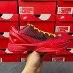 Red low-top basketball shoe with black swoosh, neon green laces, glossy sole.