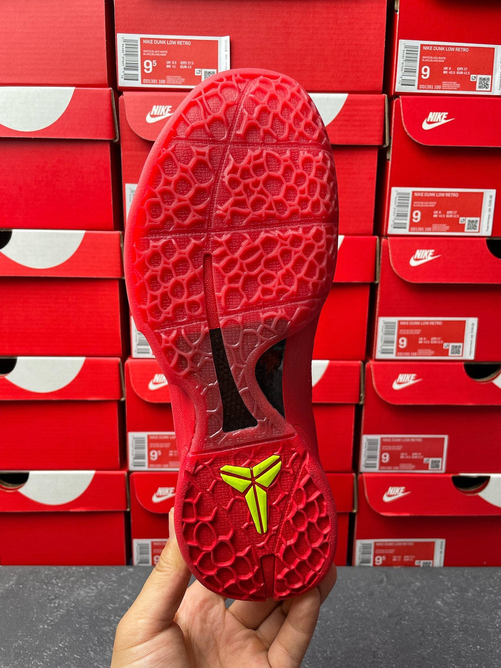 Red shoe sole and outsole pattern with neon green heel marking, bottom view.