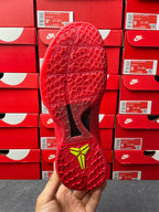 Red shoe sole and outsole pattern with neon green heel marking, bottom view.