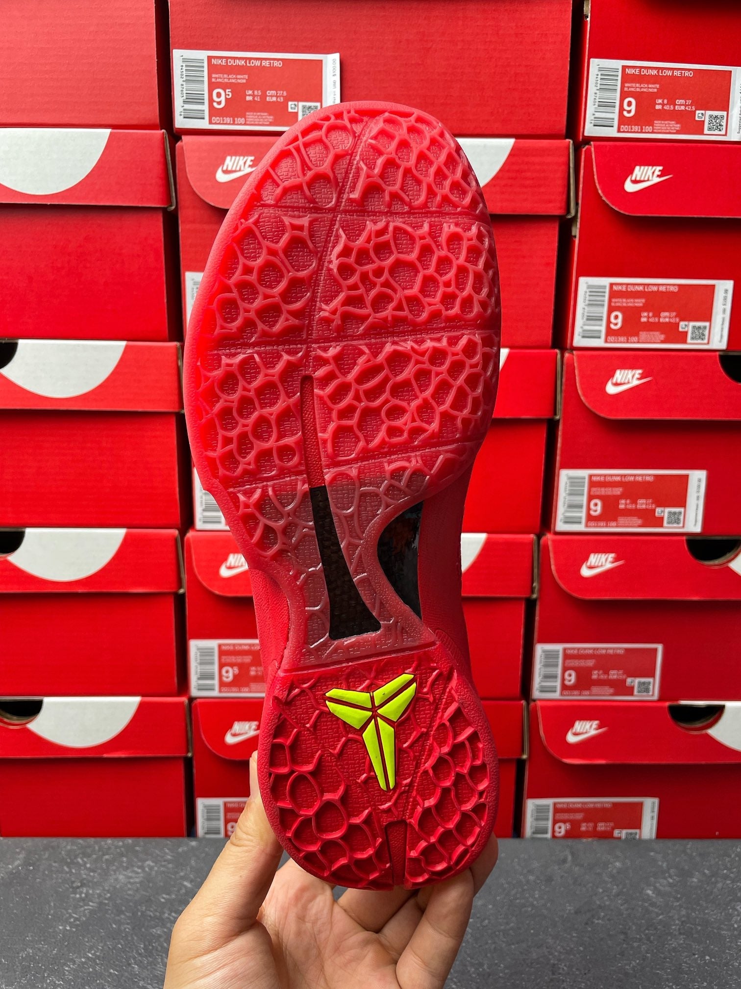 Red shoe sole and outsole pattern with neon green heel marking, bottom view.