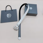White and dark reversible belt with ornate silver buckle, hanging end and holes