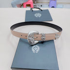 Chrome belt laid flat with beige strap, silver ornate buckle, and black edge
