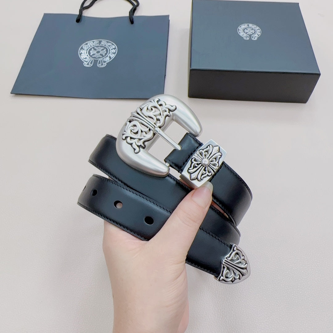 Chrome belt held in hand, close-up of dark blue strap and silver ornate buckle