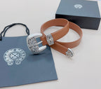 Brown leather belt with ornate silver buckle and engraved decorative accents