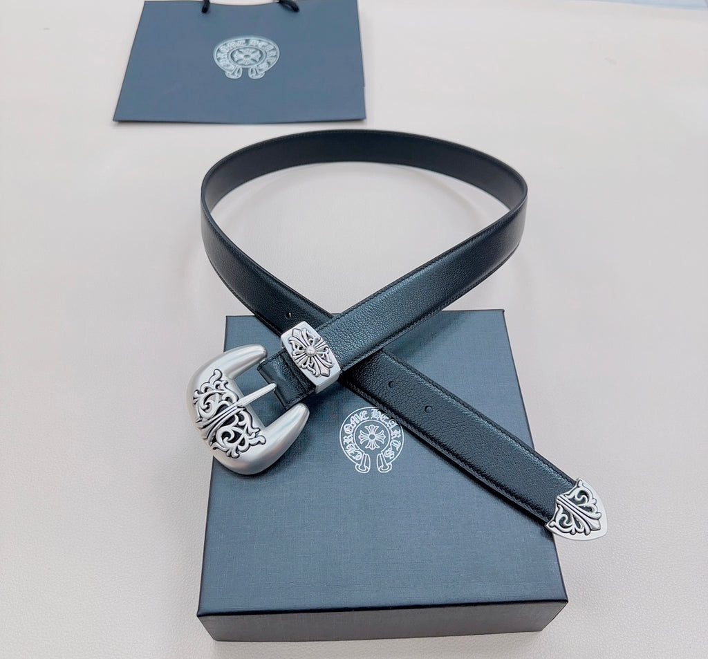Dark blue leather belt draped over box with silver ornate buckle and matching decorative strap end.