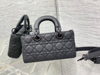 Quilted black handbag with top handles and adjustable crossbody strap
