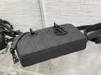 Black quilted handbag top with central emblem and shoulder strap