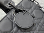 Black quilted handbag charm tag reading “Christian Dior”