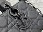 Black quilted handbag clasp hardware close-up on textured leather