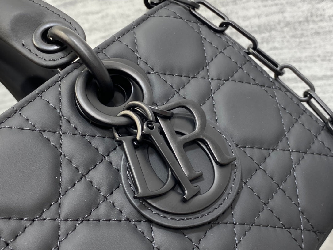Black quilted handbag clasp hardware close-up on textured leather