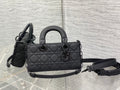 Quilted black handbag with top handles and detachable shoulder strap
