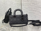 Quilted black handbag with top handles and detachable shoulder strap
