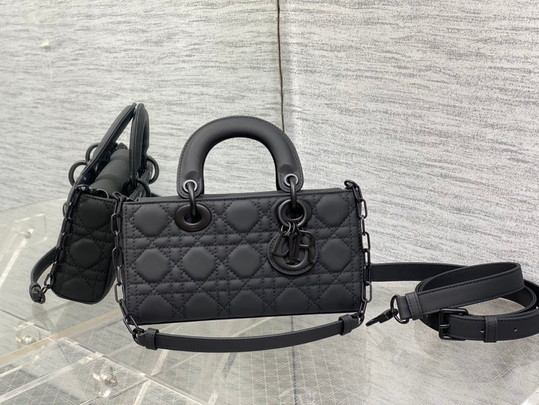 Quilted black handbag with top handles and detachable shoulder strap