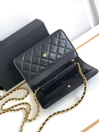 Black leather flap shoulder bag open to reveal compartments and gold-tone hardware
