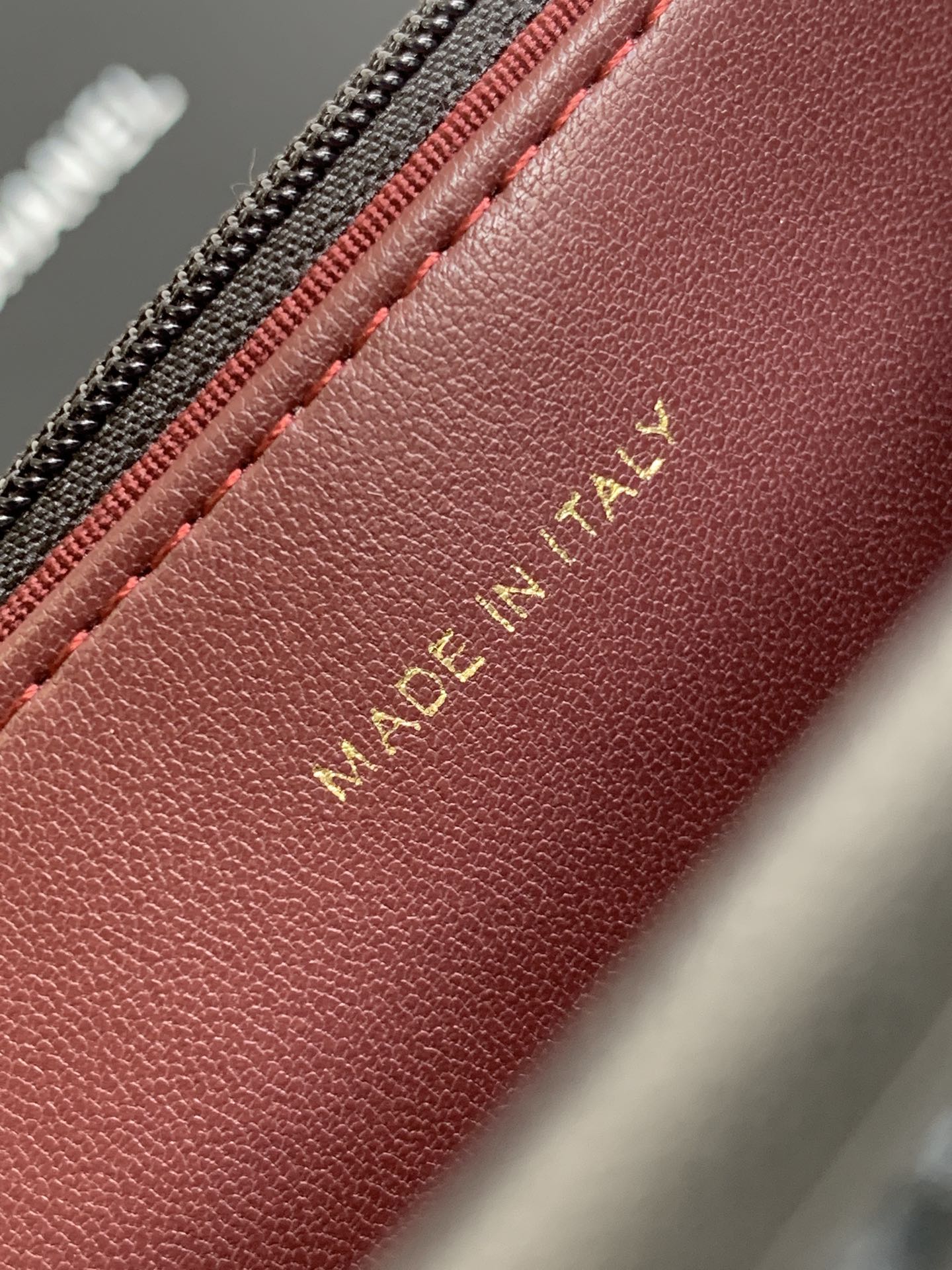 Burgundy leather bag interior with “MADE IN ITALY” stamp in gold lettering