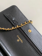 Black leather wristlet-style bag with zipper, gold-tone pull and CHANEL logo detail
