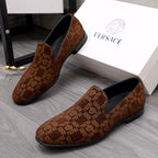 Versace luxury slip-on shoes in brown with repeating logo pattern, black interior and sole.