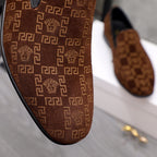Versace luxury slip-on shoe upper in brown with repeating logo pattern and black edge.