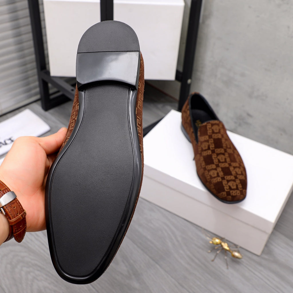 Versace luxury slip-on shoe outsole with textured black tread and brown patterned upper edge.