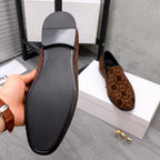 Versace luxury slip-on shoe outsole with textured black tread and brown patterned upper edge.