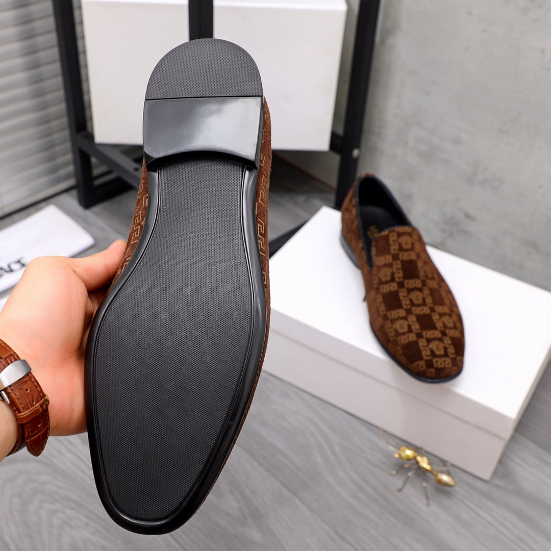 Versace luxury slip-on shoe outsole with textured black tread and brown patterned upper edge.