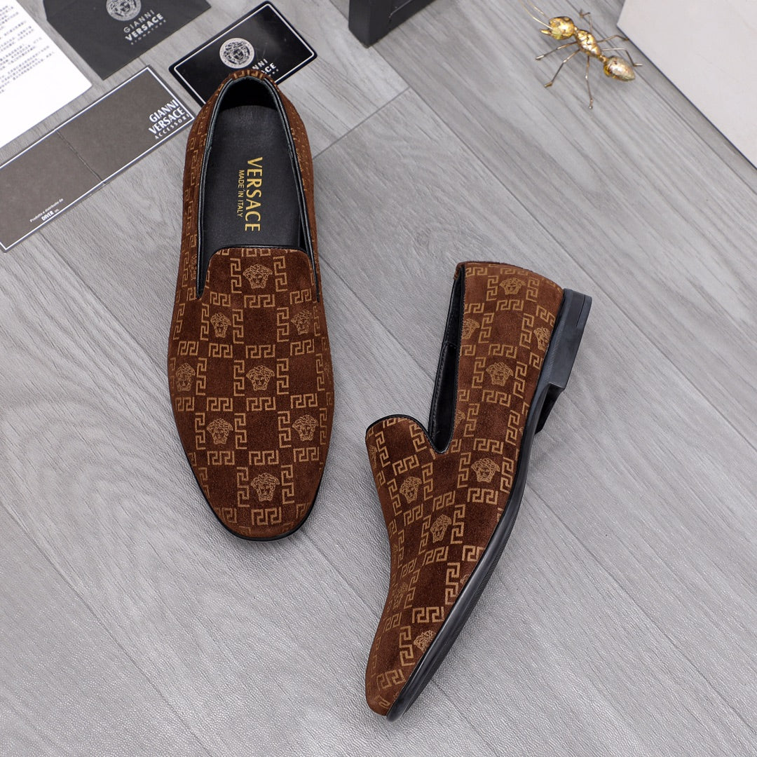 Versace luxury slip-on shoes in brown with repeating logo pattern and black lining.