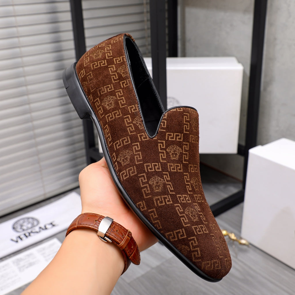 Versace luxury slip-on shoe in brown with repeating logo pattern and black sole.