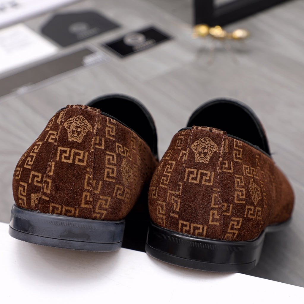 Versace luxury slip-on shoes with brown patterned uppers and black rubber heel sections.