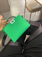 Green Fendi mini handbag angled view, top handle and dark strap with buckle