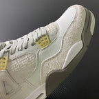 Mid-top sneaker close-up with textured beige overlay and yellow lace tabs