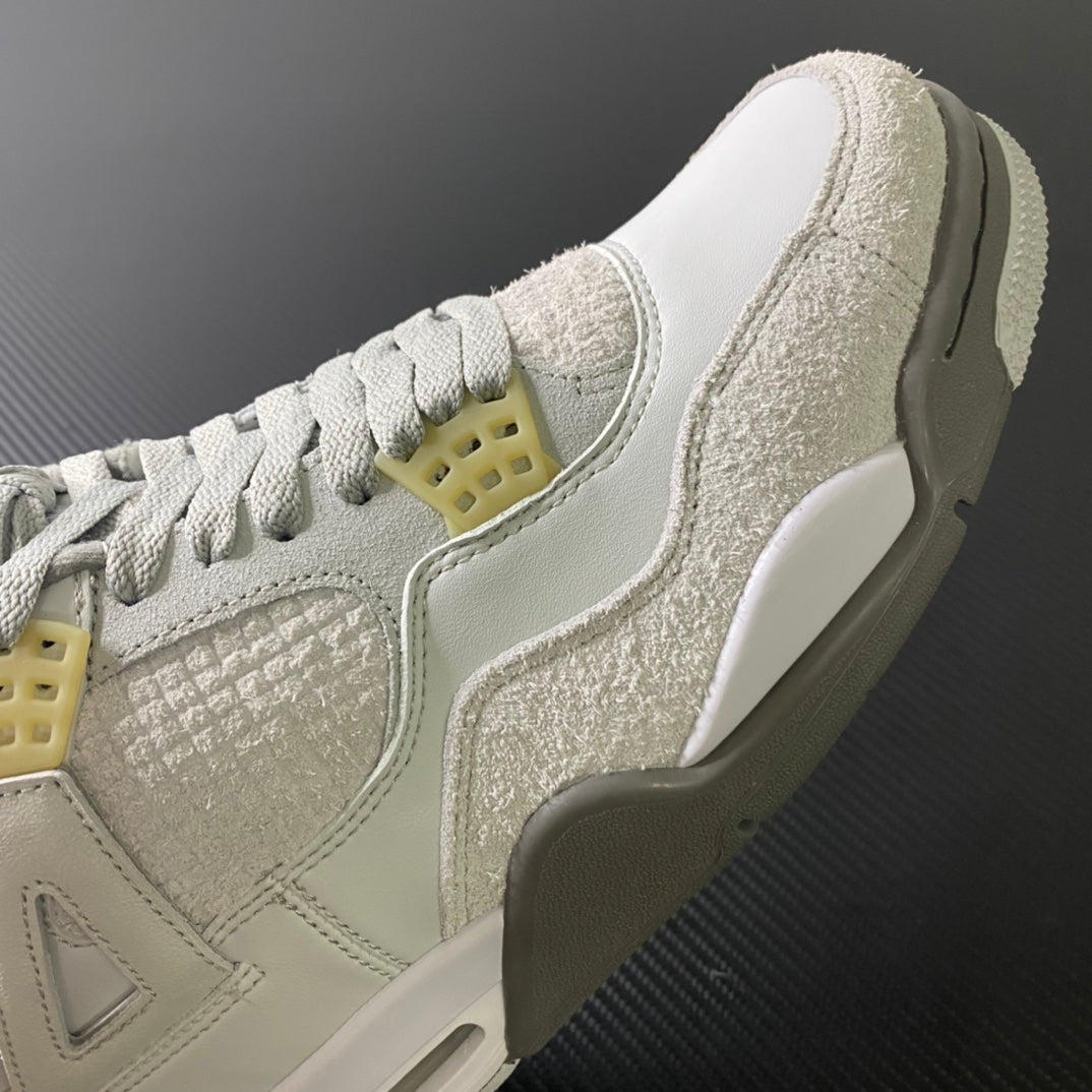 Mid-top sneaker close-up with textured beige overlay and yellow lace tabs