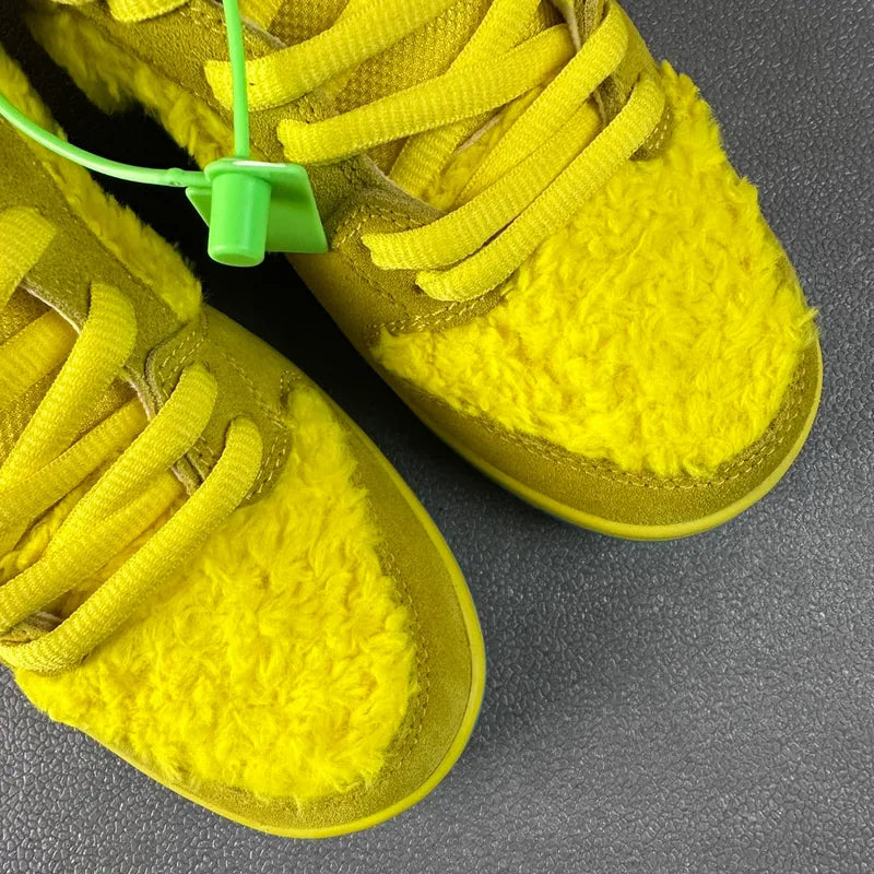 Yellow fuzzy low-top sneakers with green laces and thick blue accent sole edge