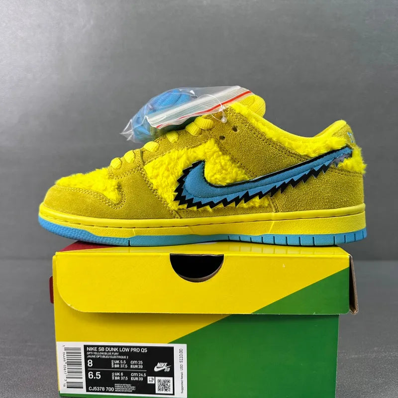 Yellow low-top sneakers with blue swoosh and zigzag side detail, on box