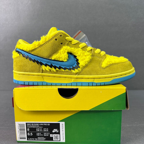 Yellow Nike Dunk SB Low sneakers with blue swoosh and zigzag trim
