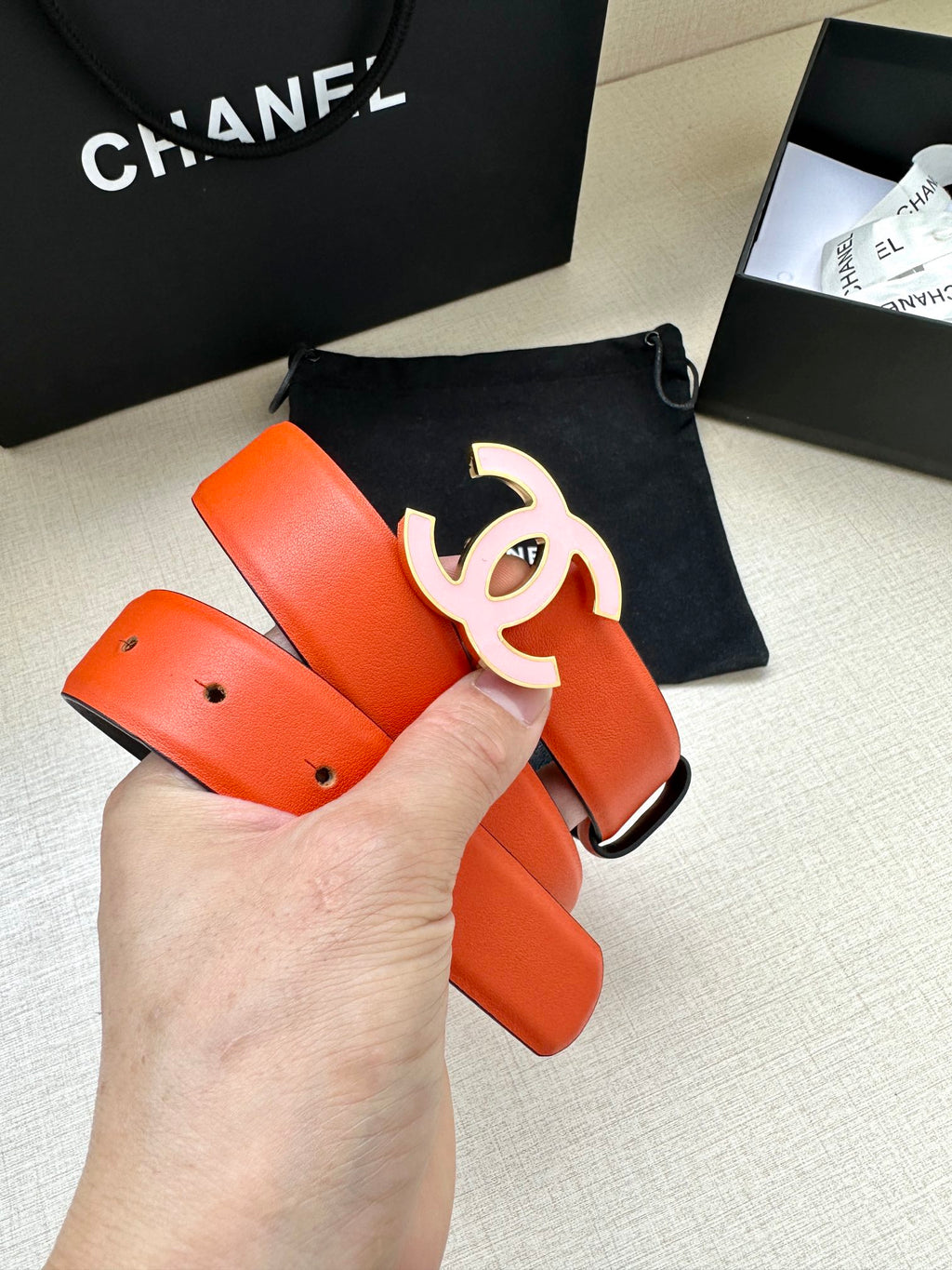 Orange Chanel belt with silver-tone CC buckle and adjustable strap holes
