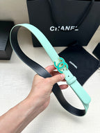 Mint Chanel belt held up, showing turquoise CC buckle and leather strap with holes.