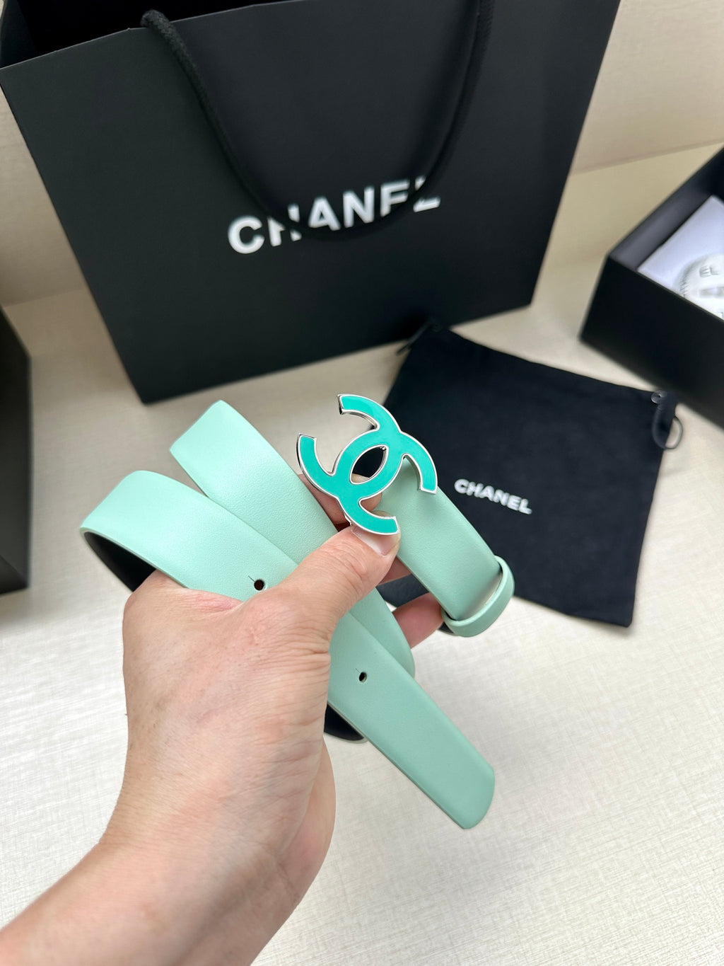 Mint Chanel belt with turquoise CC buckle, adjustable holes, and leather strap end.