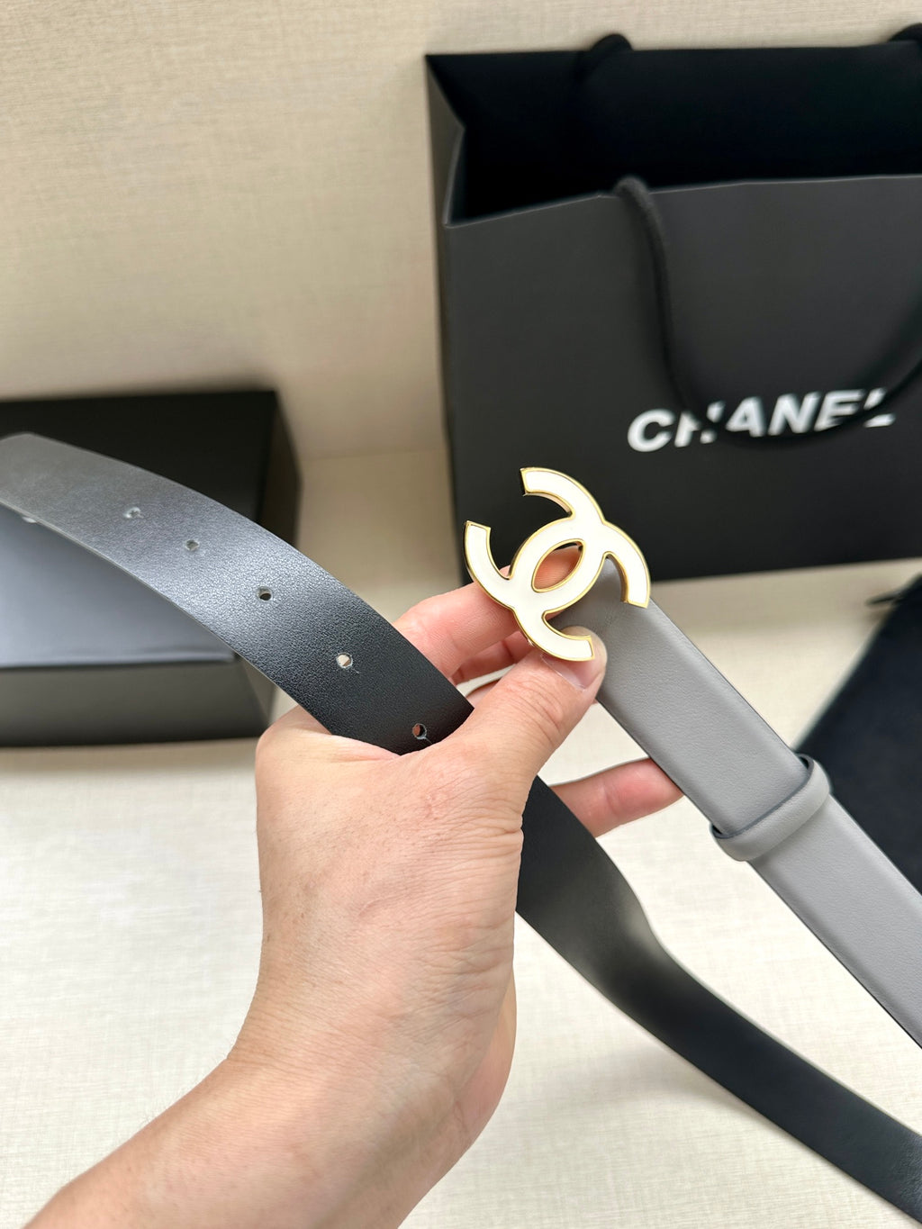 Gray leather Chanel belt with gold-tone CC buckle centered on strap