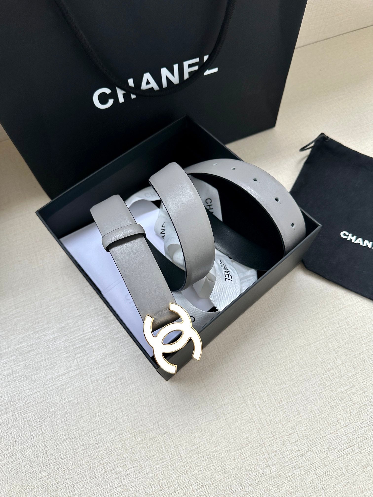 Gray leather Chanel belt with gold-tone CC buckle and wrapped loops in box