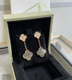 Gold clover-like drop earrings with pavé details and pastel blue flower centers