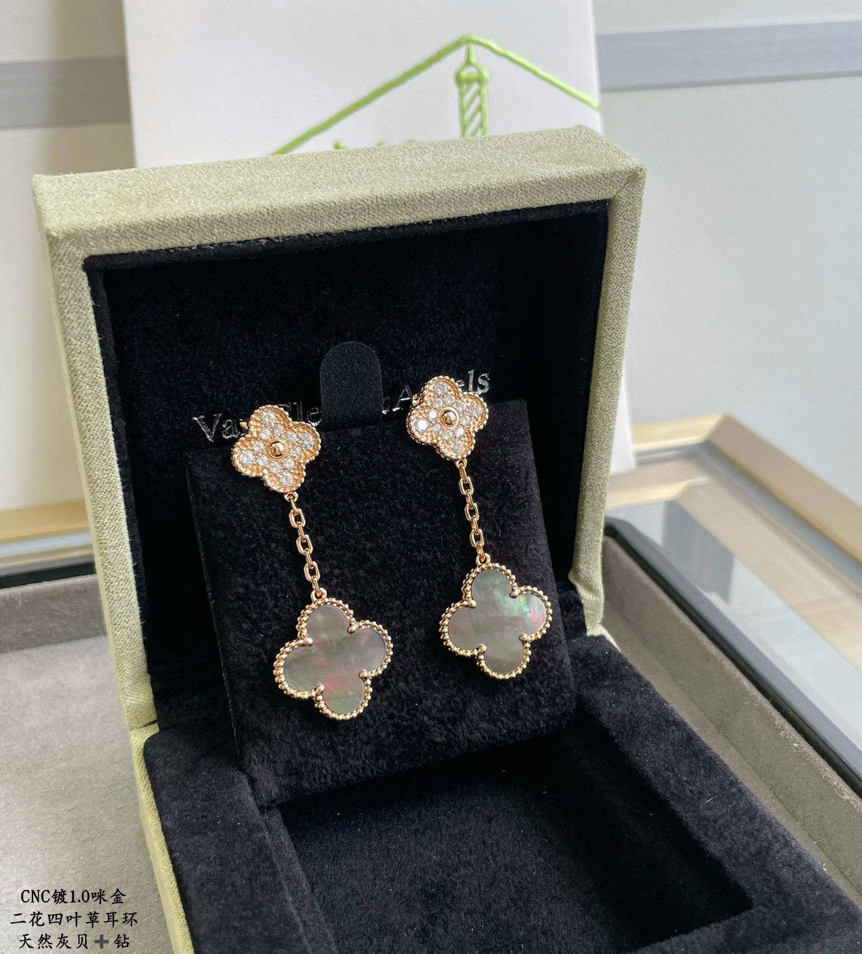 Gold clover-like drop earrings with pavé details and pastel blue flower centers