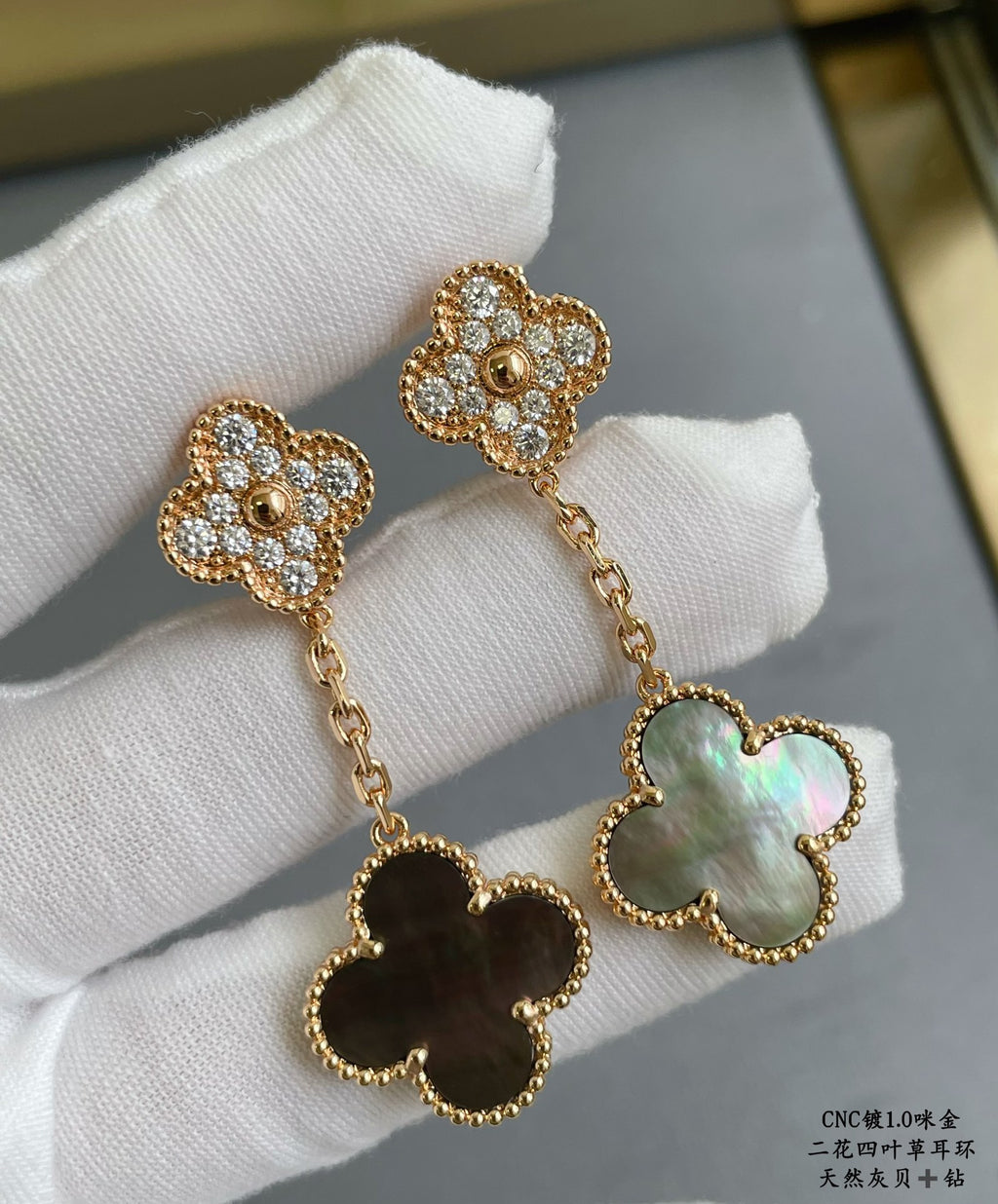 Gold clover stud earrings with chain drops and iridescent blue-green pendant