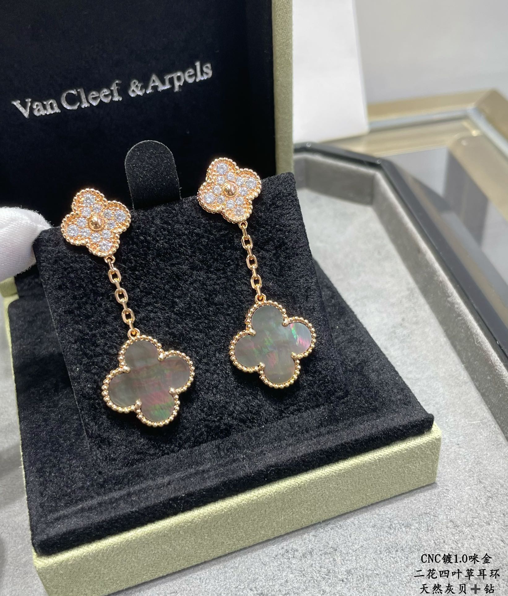 Gold clover drop earrings in display box with sparkling studs and pastel blue centers
