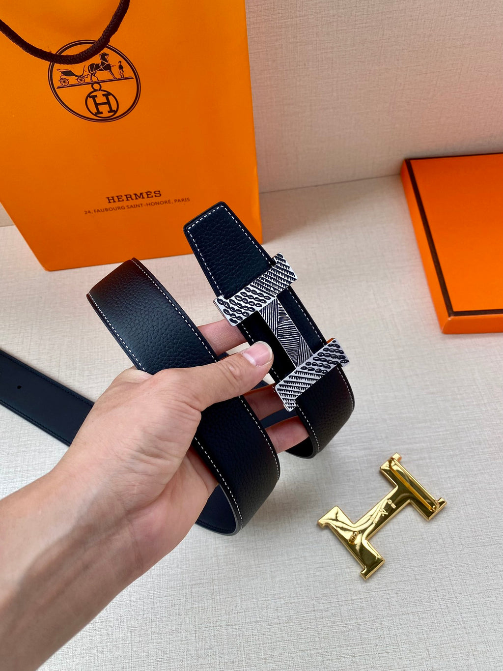 Leather belt with dark blue leather strap and textured metal buckle