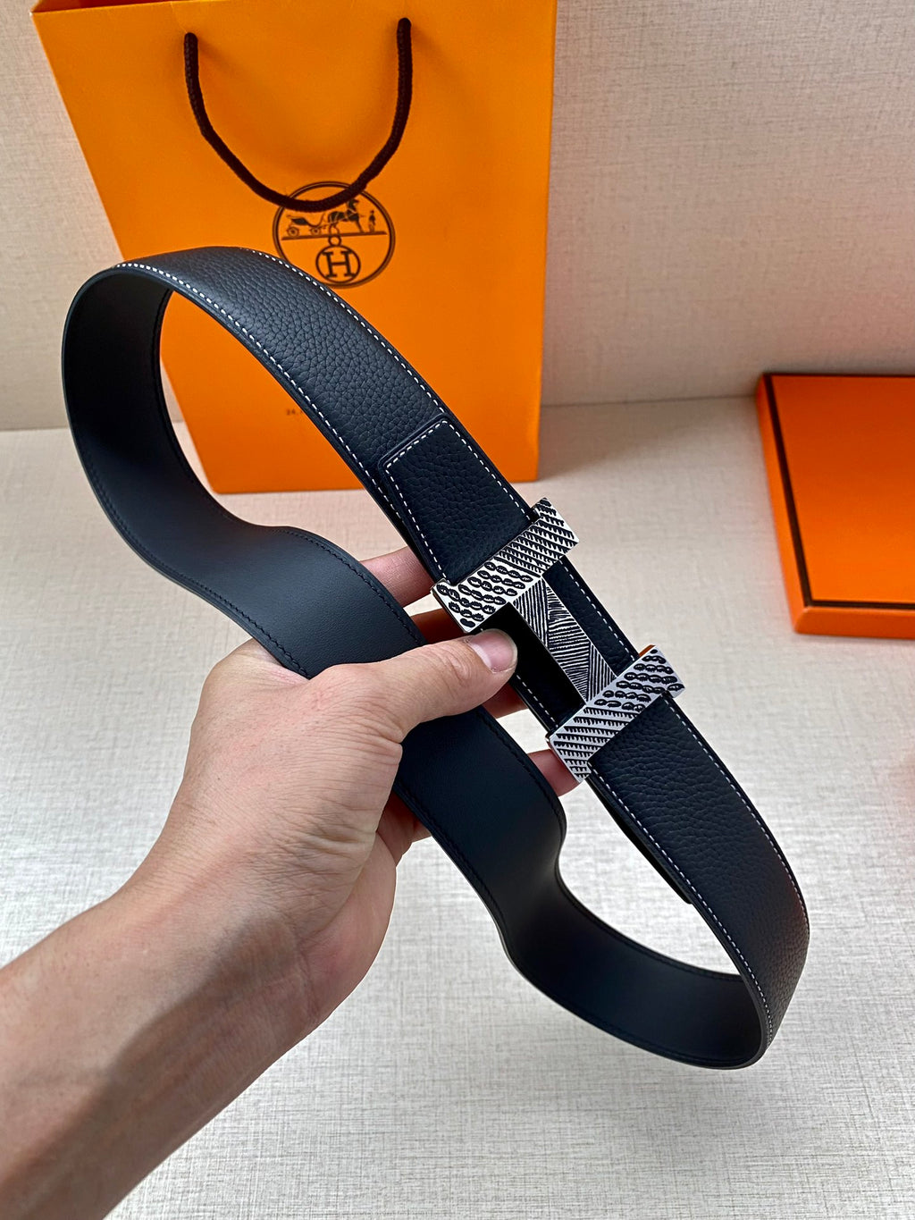 Leather belt with dark blue strap and patterned silver-and-gold buckle
