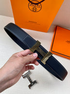 Leather belt with dark blue textured strap and gold-toned buckle detail