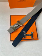Two-tone leather belt with textured buckle strap and gold-tone clasp, close-up view