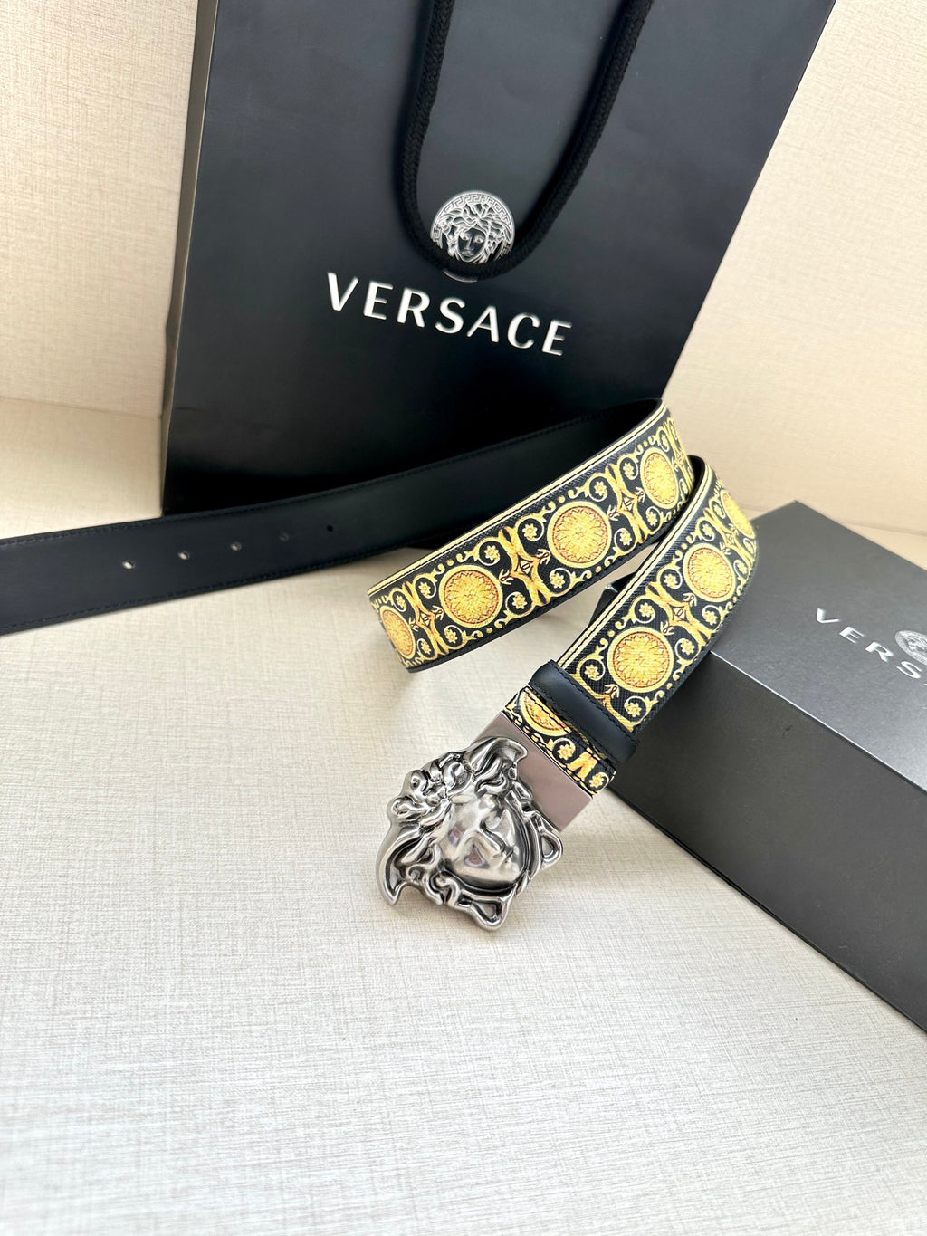 Navy leather belt with gold baroque pattern and silver Medusa buckle close-up