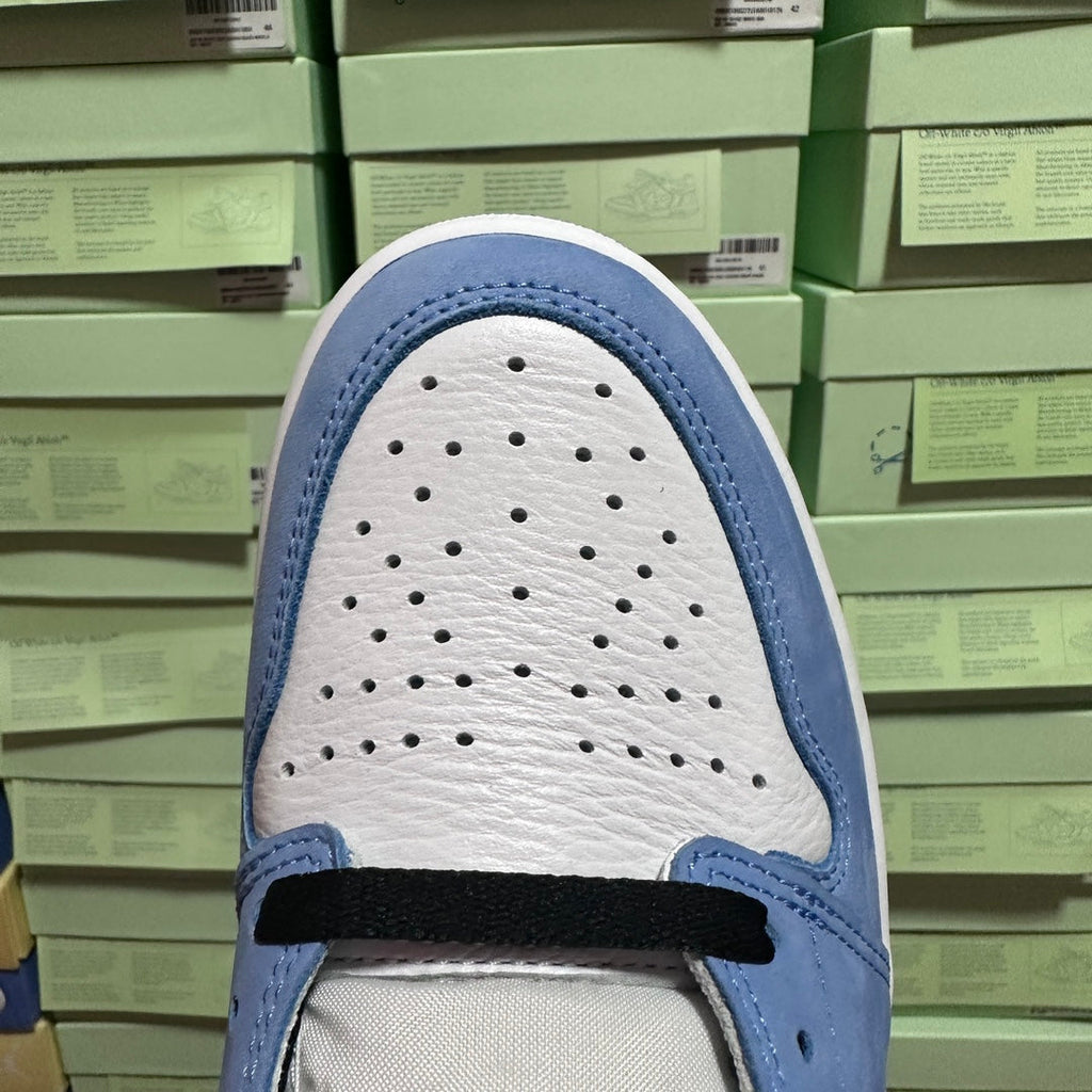 Light blue and white shoe toe box with perforations and lace strap.